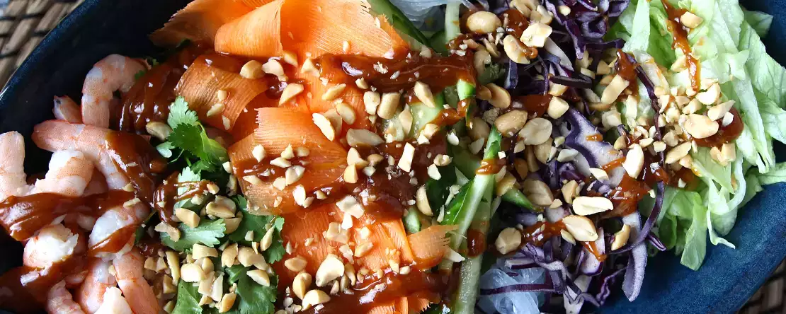 Pirinç eriştesi, karides ve baharatlı yer fıstığı soslu renkli salata